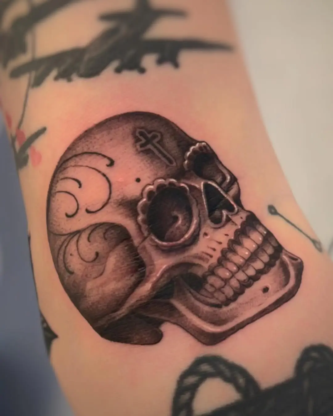 Intricate side view of a sugar skull tattoo