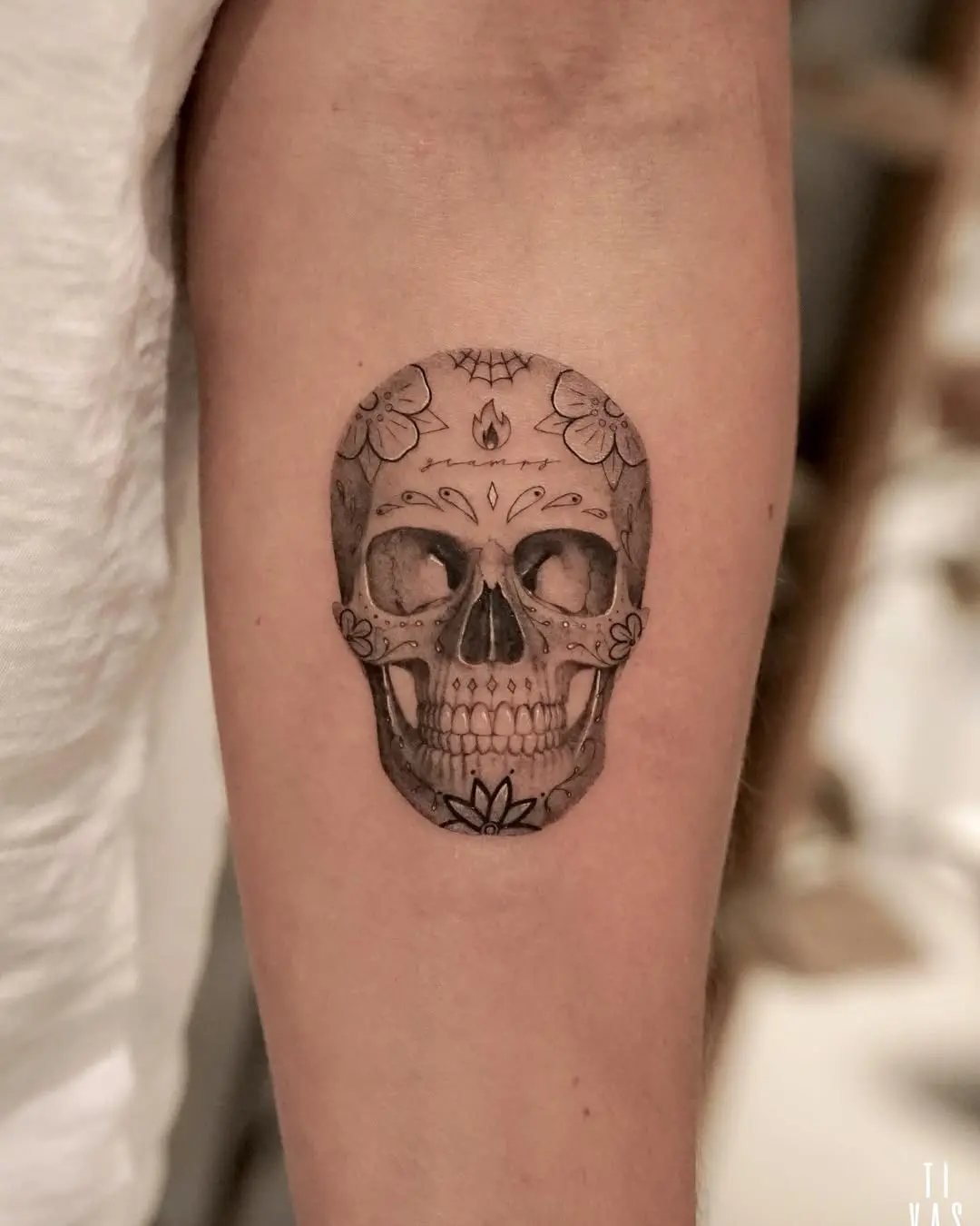 Elegant sugar skull tattoo with floral accents