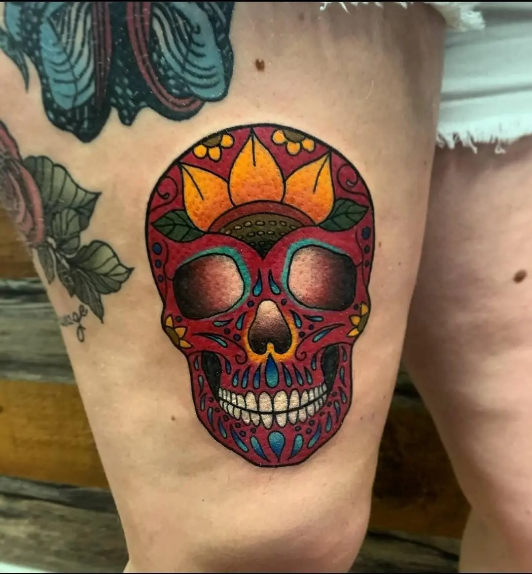 Vibrant sugar skull tattoo with floral accents