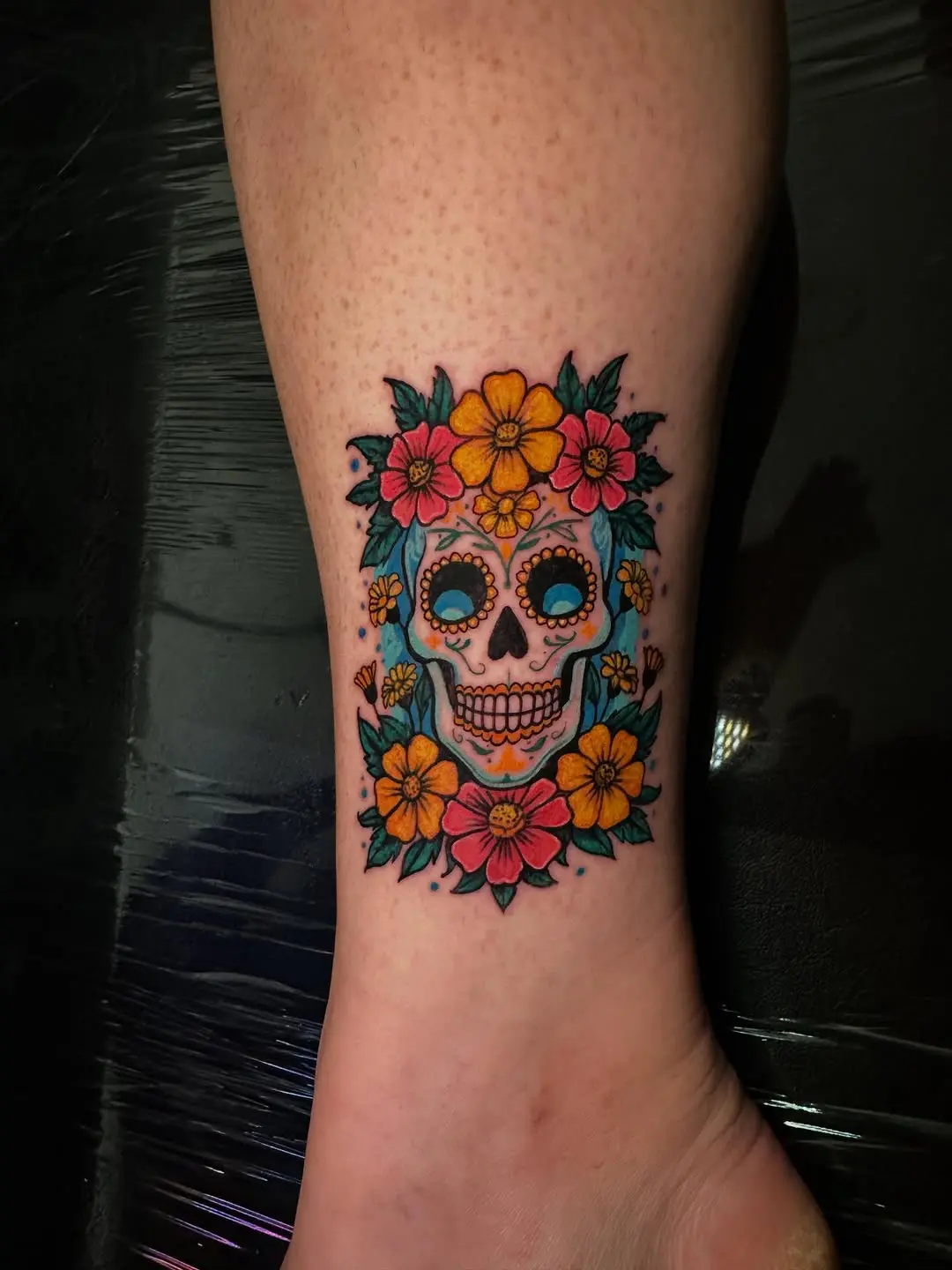Vibrant sugar skull tattoo with floral elements
