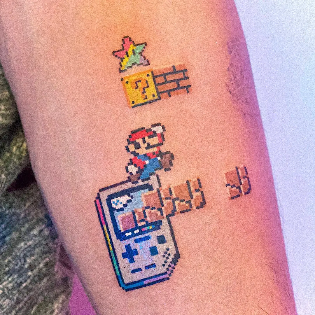 Colorful pixel art Super Mario tattoo on arm