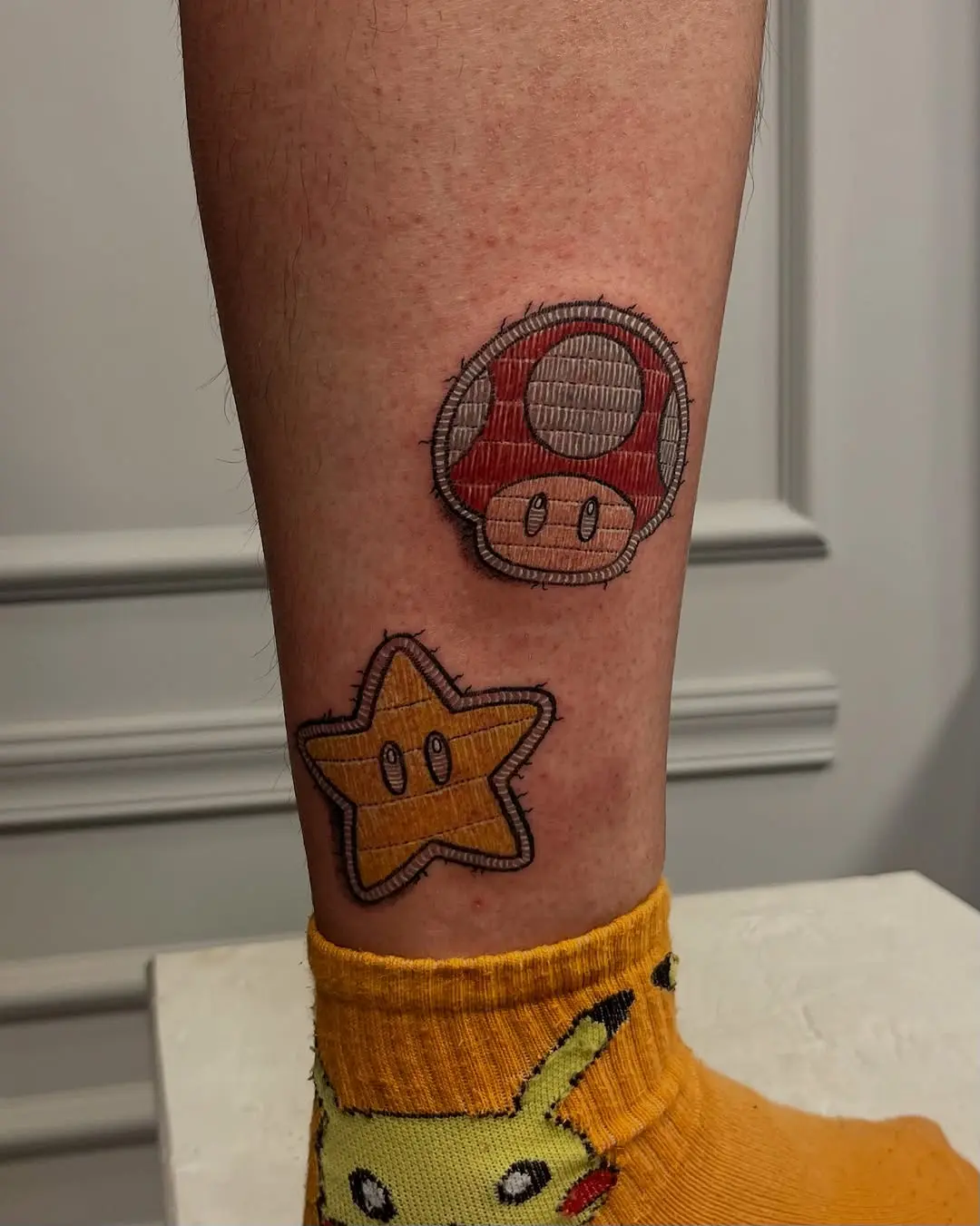 Playful Mario-themed leg tattoos for fans