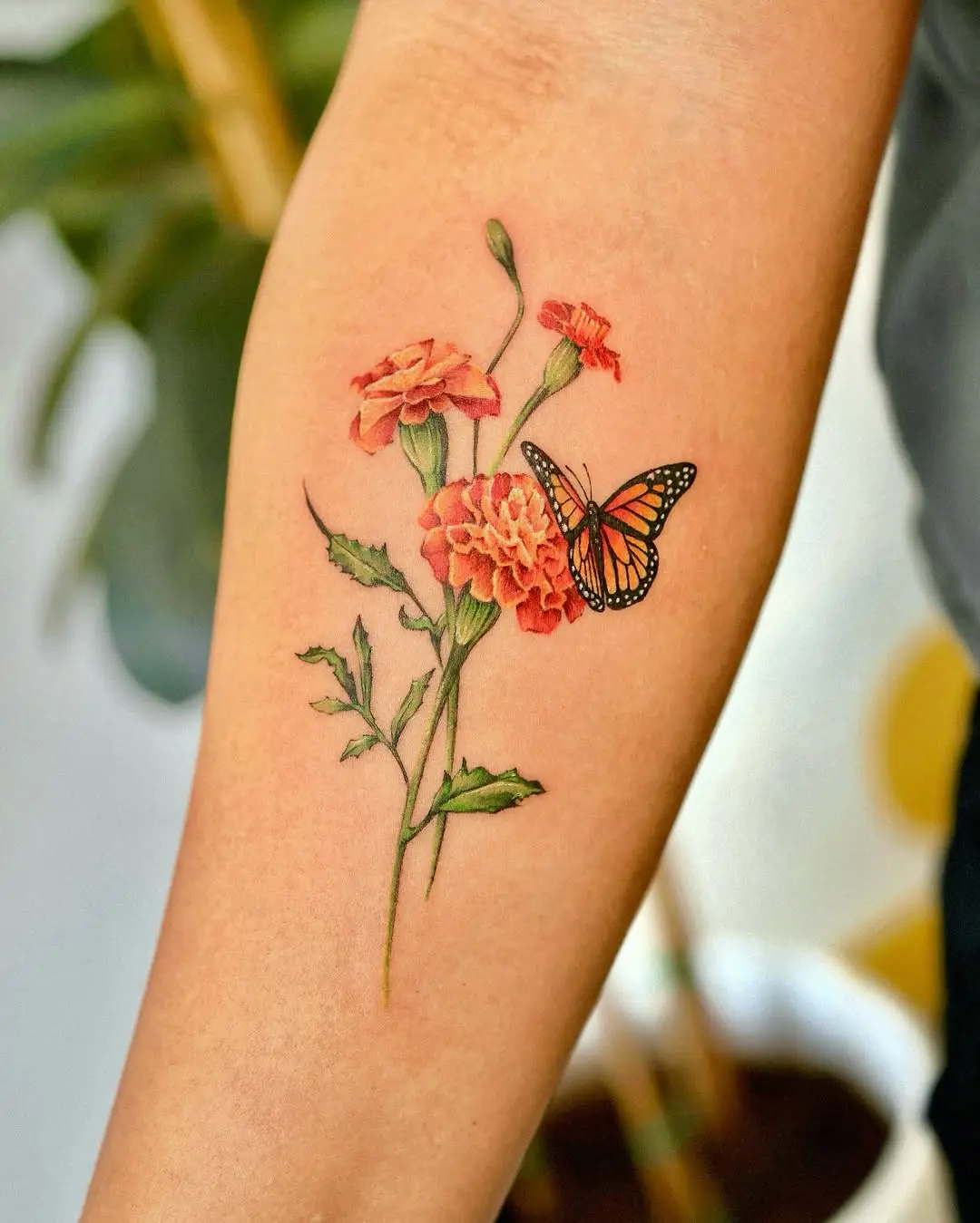 Colorful marigold tattoo featuring a butterfly