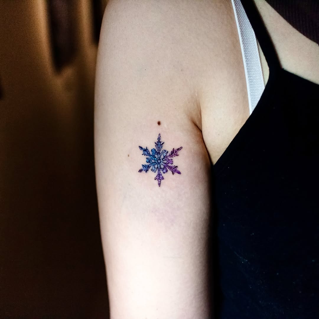 Colorful snowflake tattoo on the upper arm