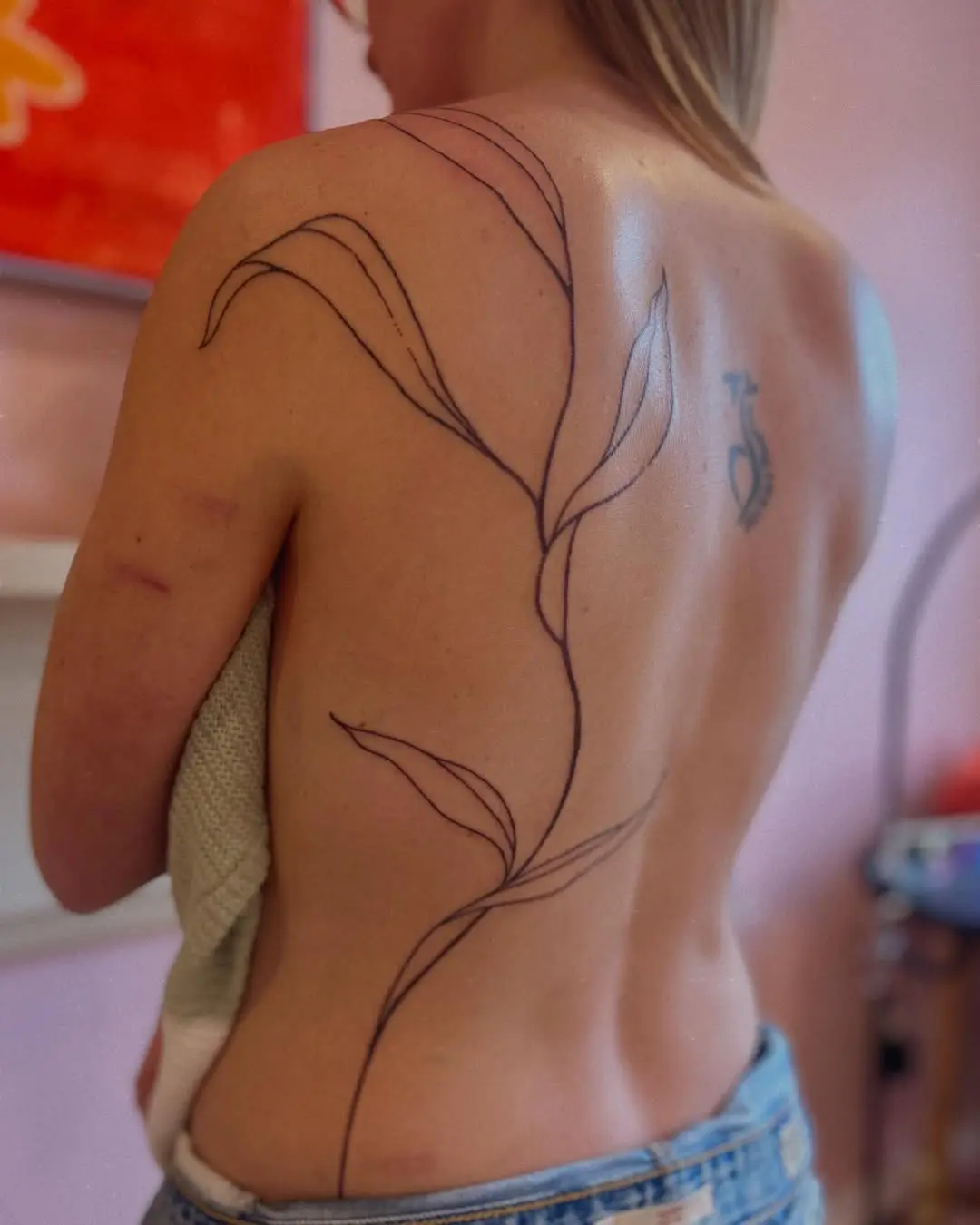 Elegant vine tattoo gracefully adorns the back