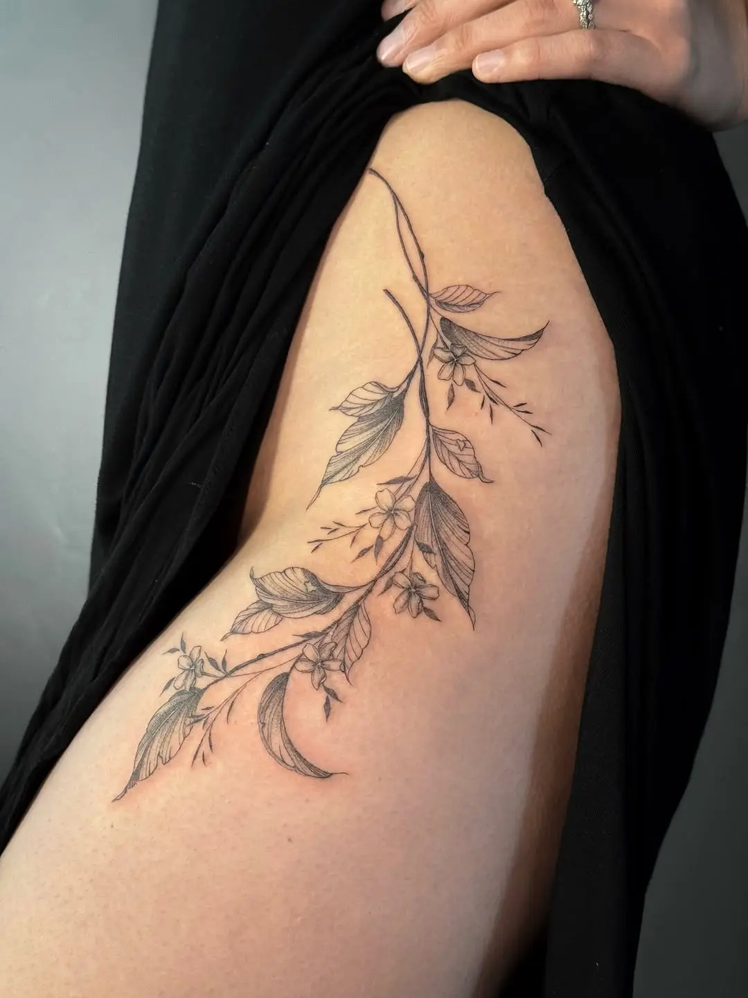 Elegant vine tattoo with delicate floral elements