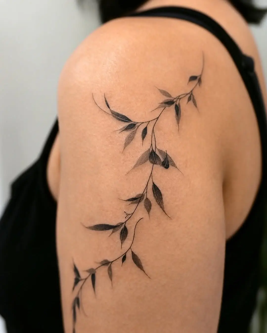 Elegant black vine tattoo accentuating the shoulder