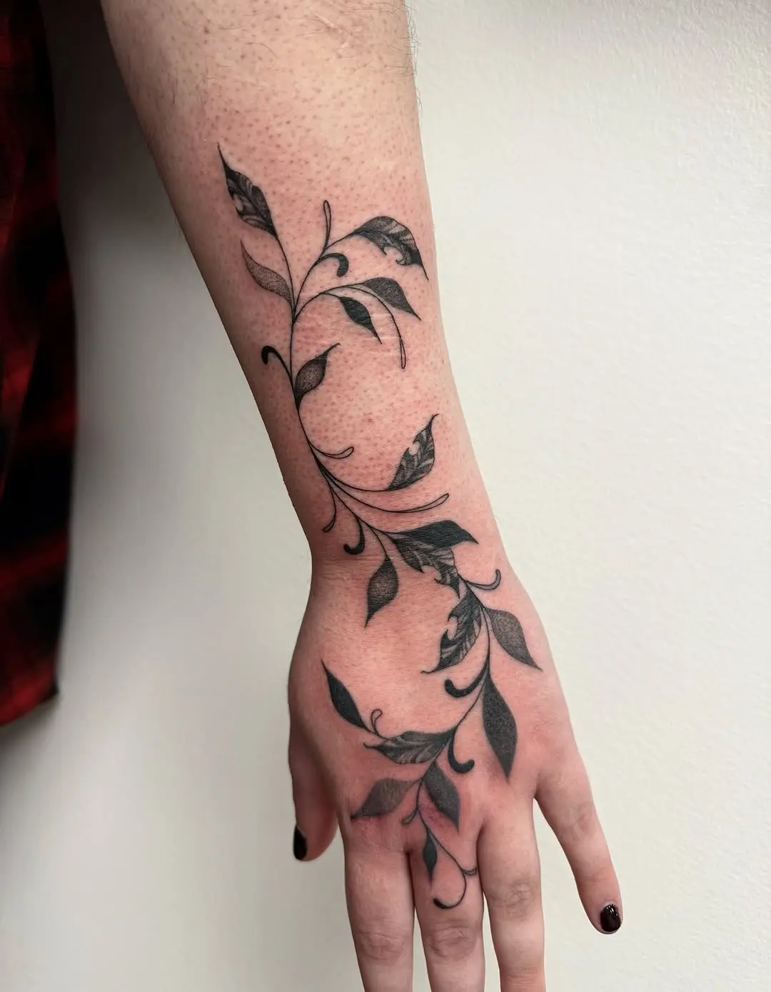 Elegant vine tattoo wraps around the wrist