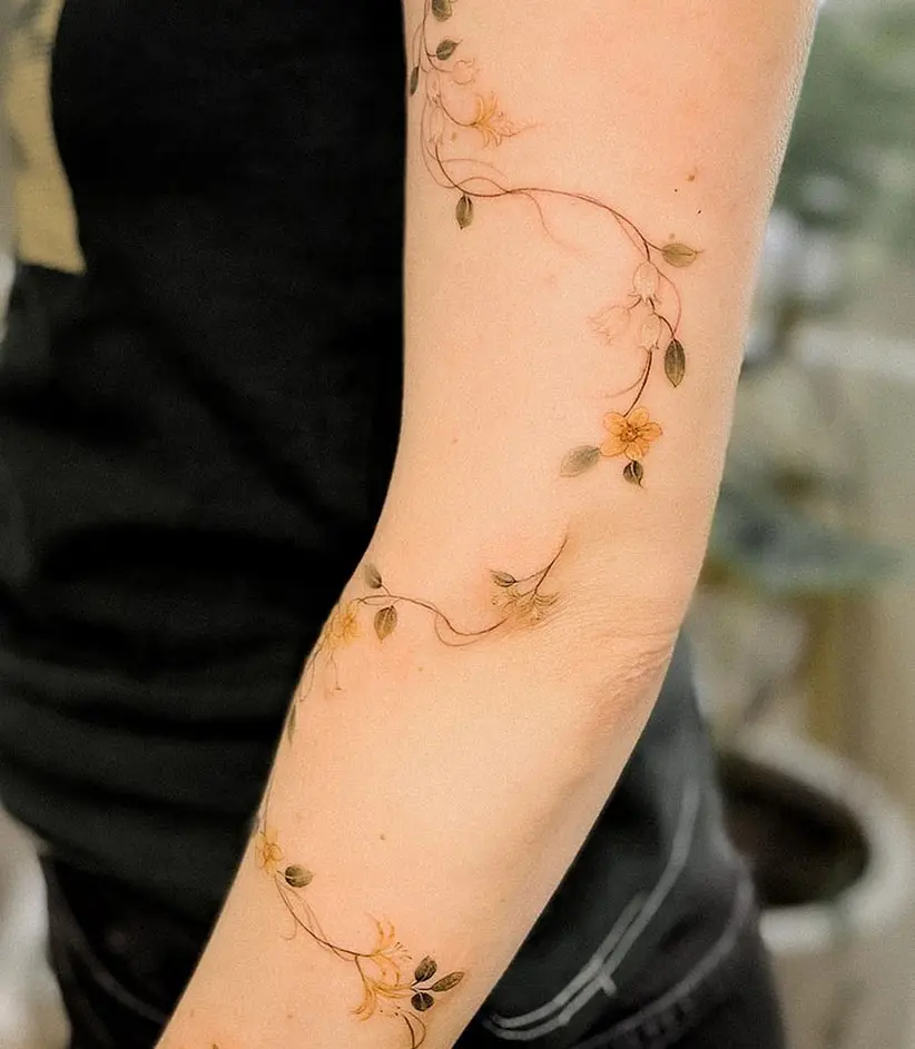 Delicate Vine Tattoo with Floral Accents