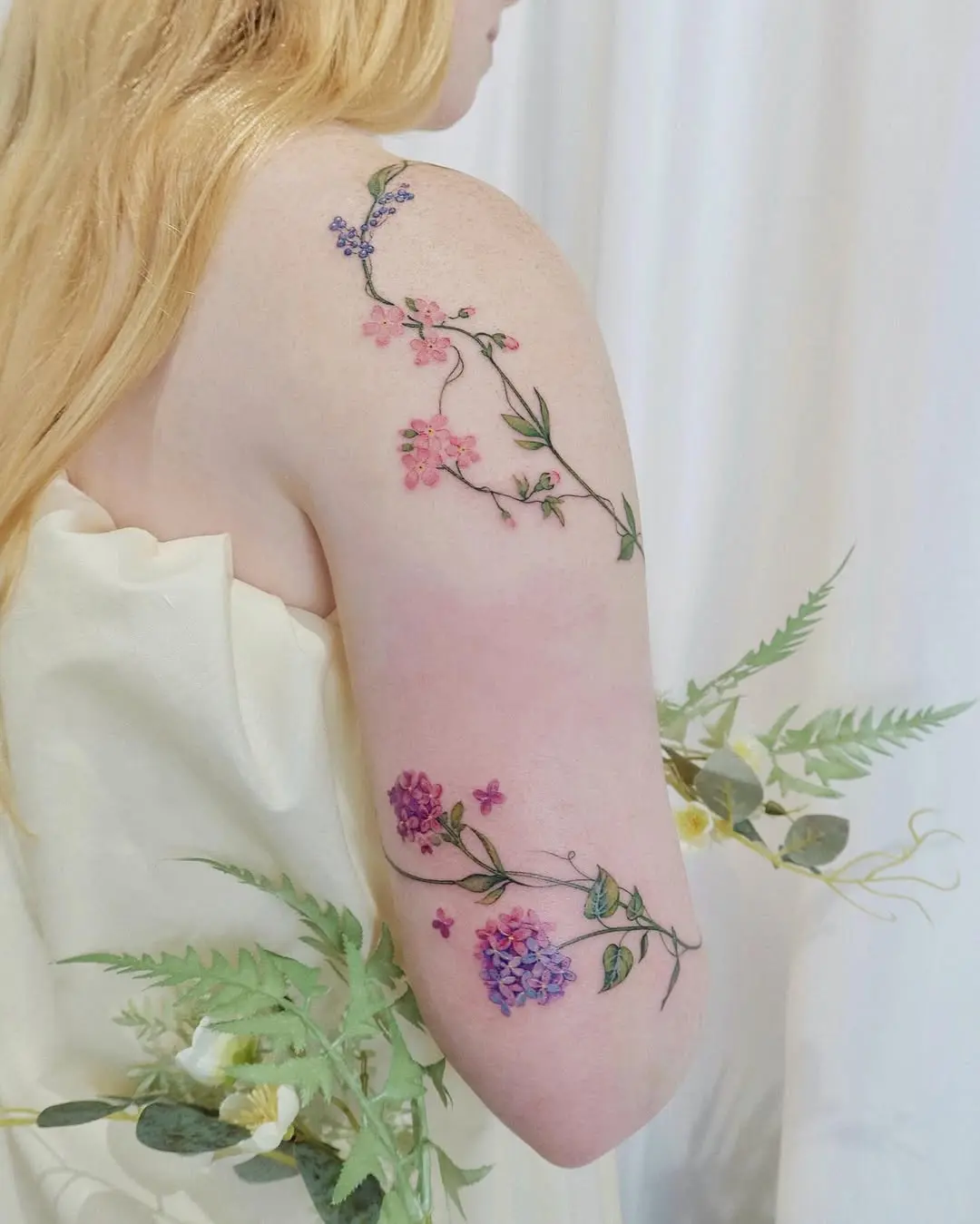 Elegant vine tattoo featuring colorful floral details