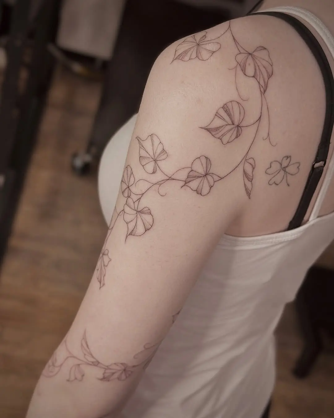 Delicate vine tattoo design wrapping around arm