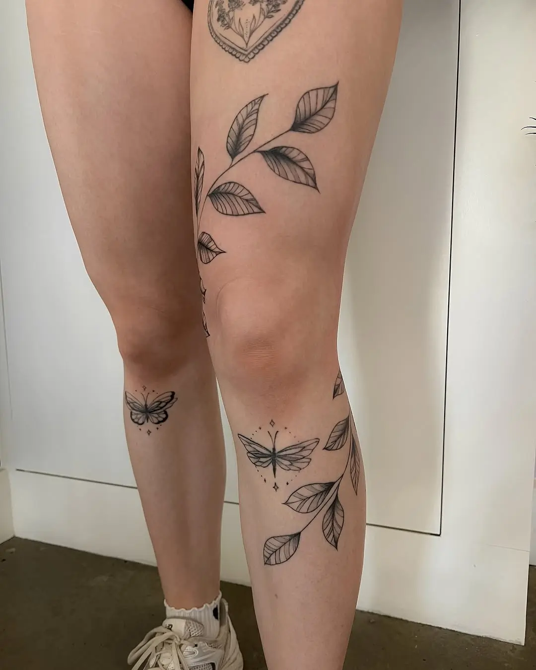 Elegant vine tattoos with butterflies on leg