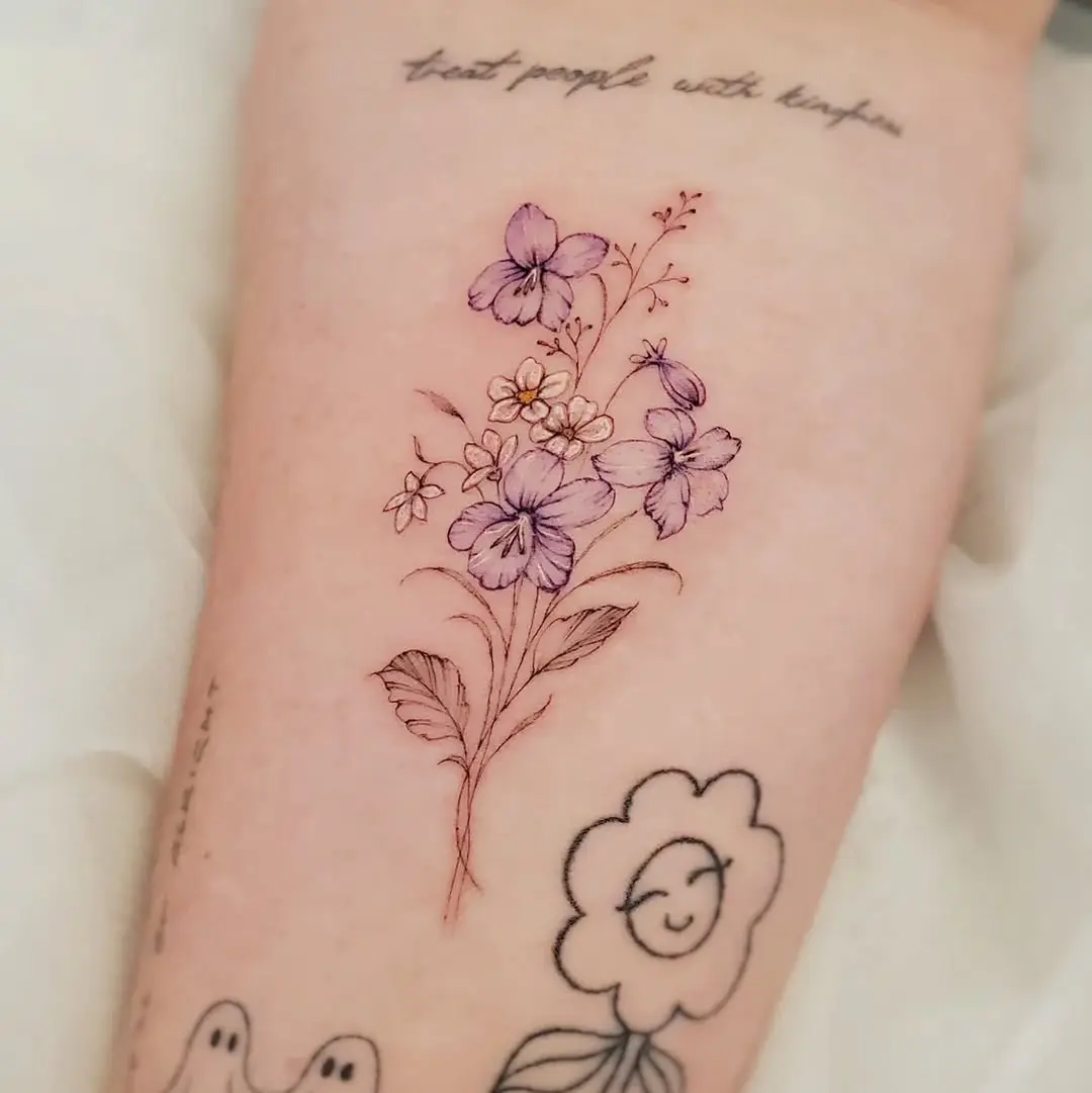 Delicate violet floral tattoo showcasing artistry