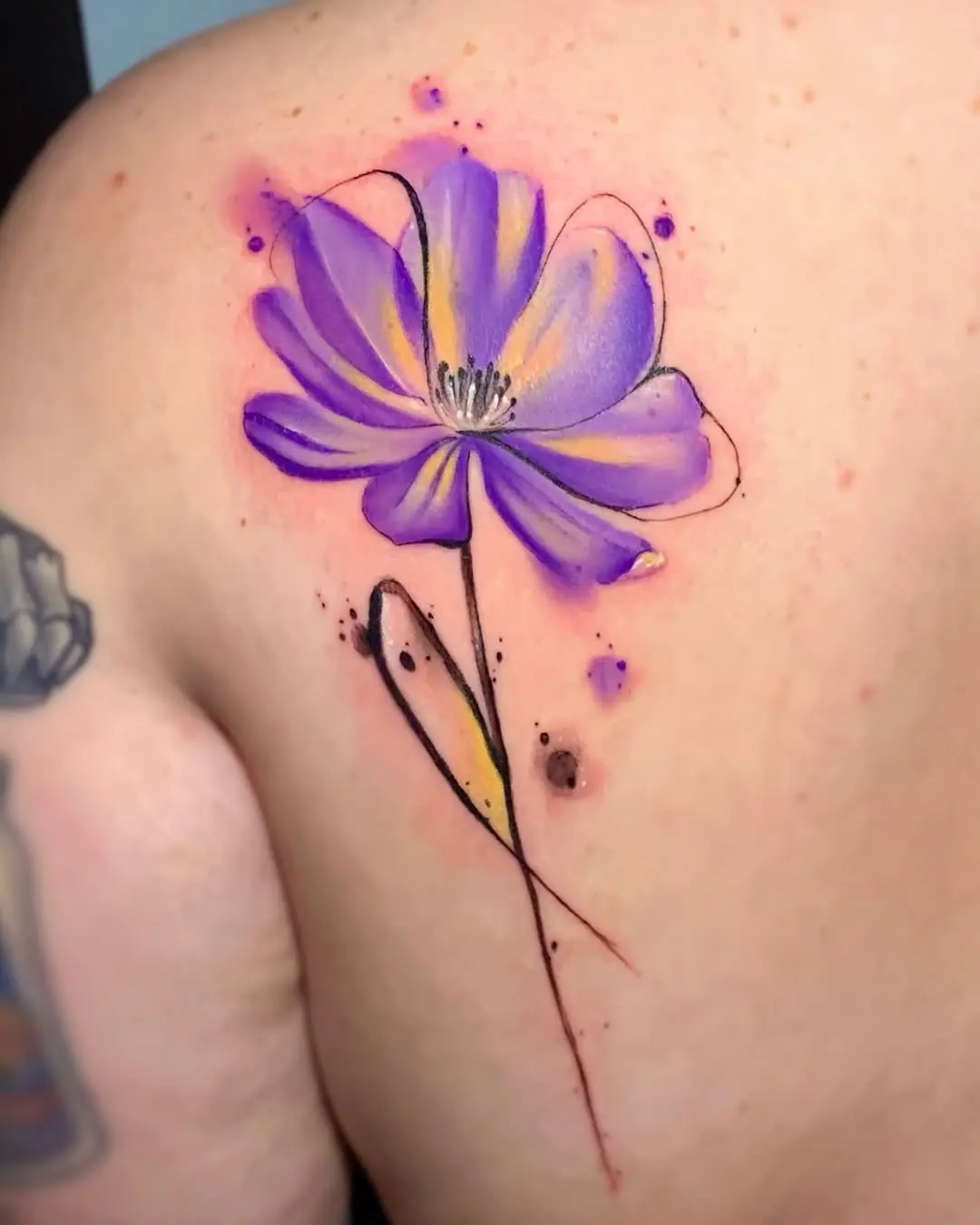 Elegant violet flower tattoo on the shoulder