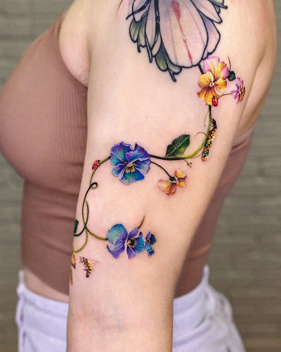 Vibrant violet floral tattoo on the arm