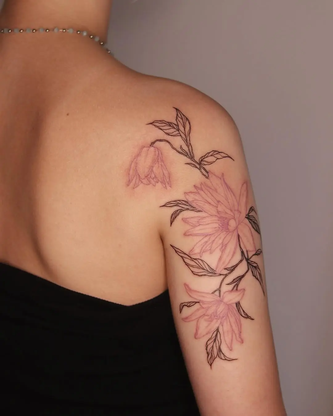 Elegant violet floral tattoo on the arm