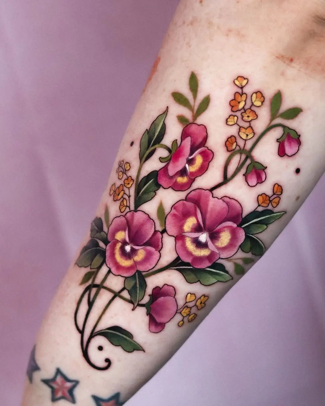 Elegant floral violet tattoo design on forearm