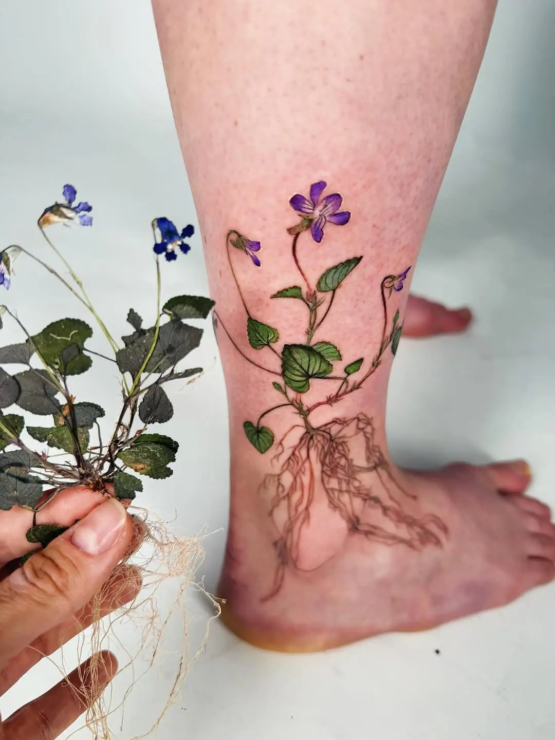 Elegant violet floral tattoo with roots