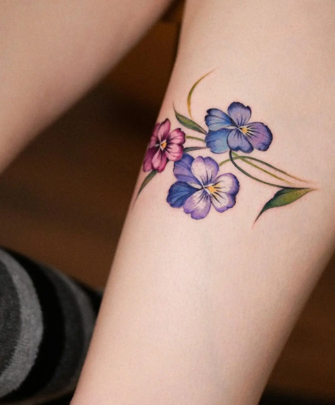 Elegant violet flowers tattoo on the leg
