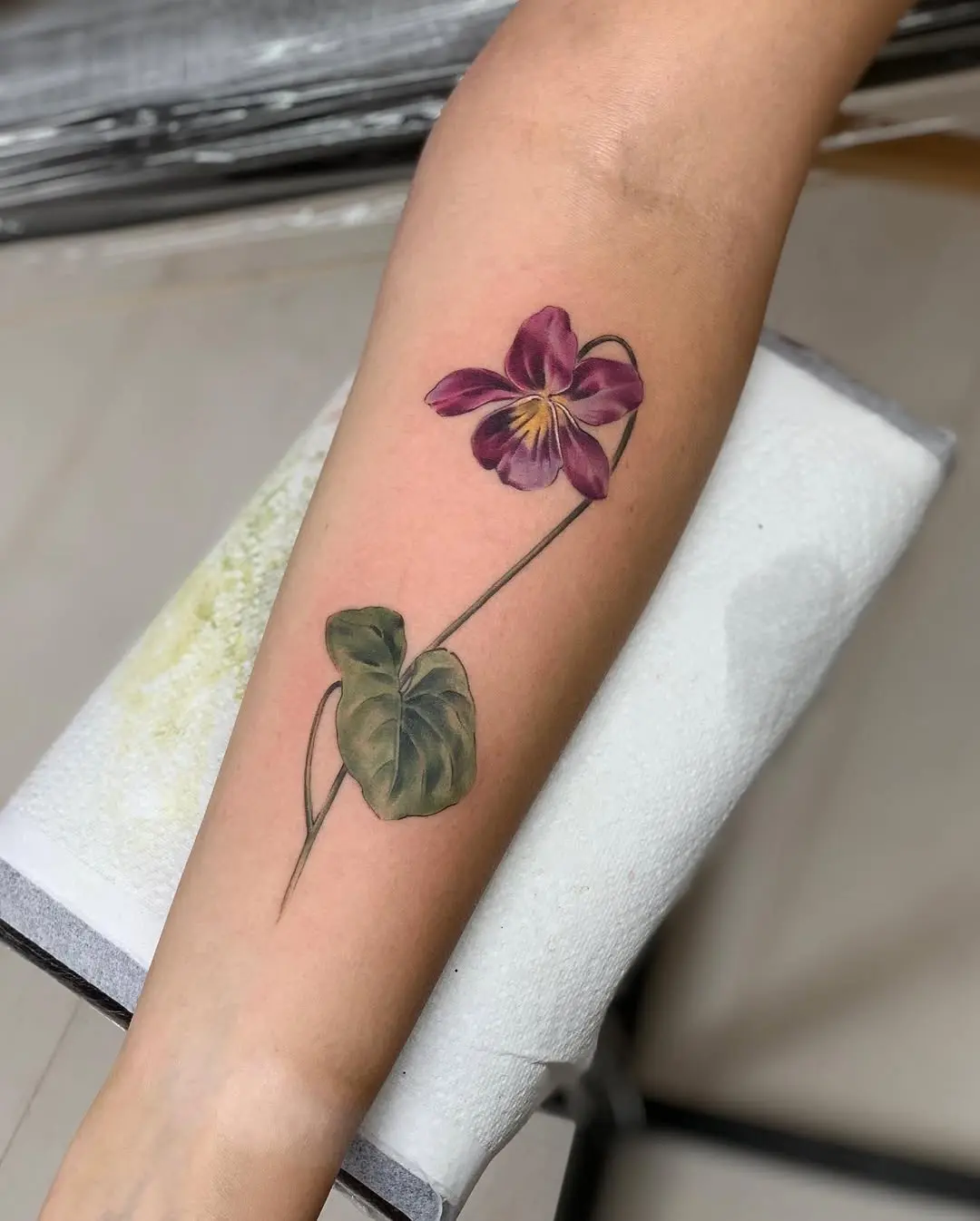 Elegant violet flower tattoo on forearm
