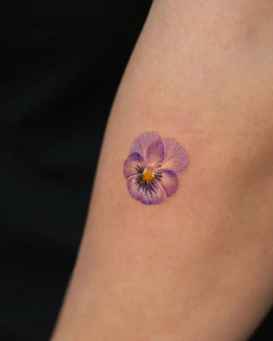 Charming violet flower tattoo on the arm