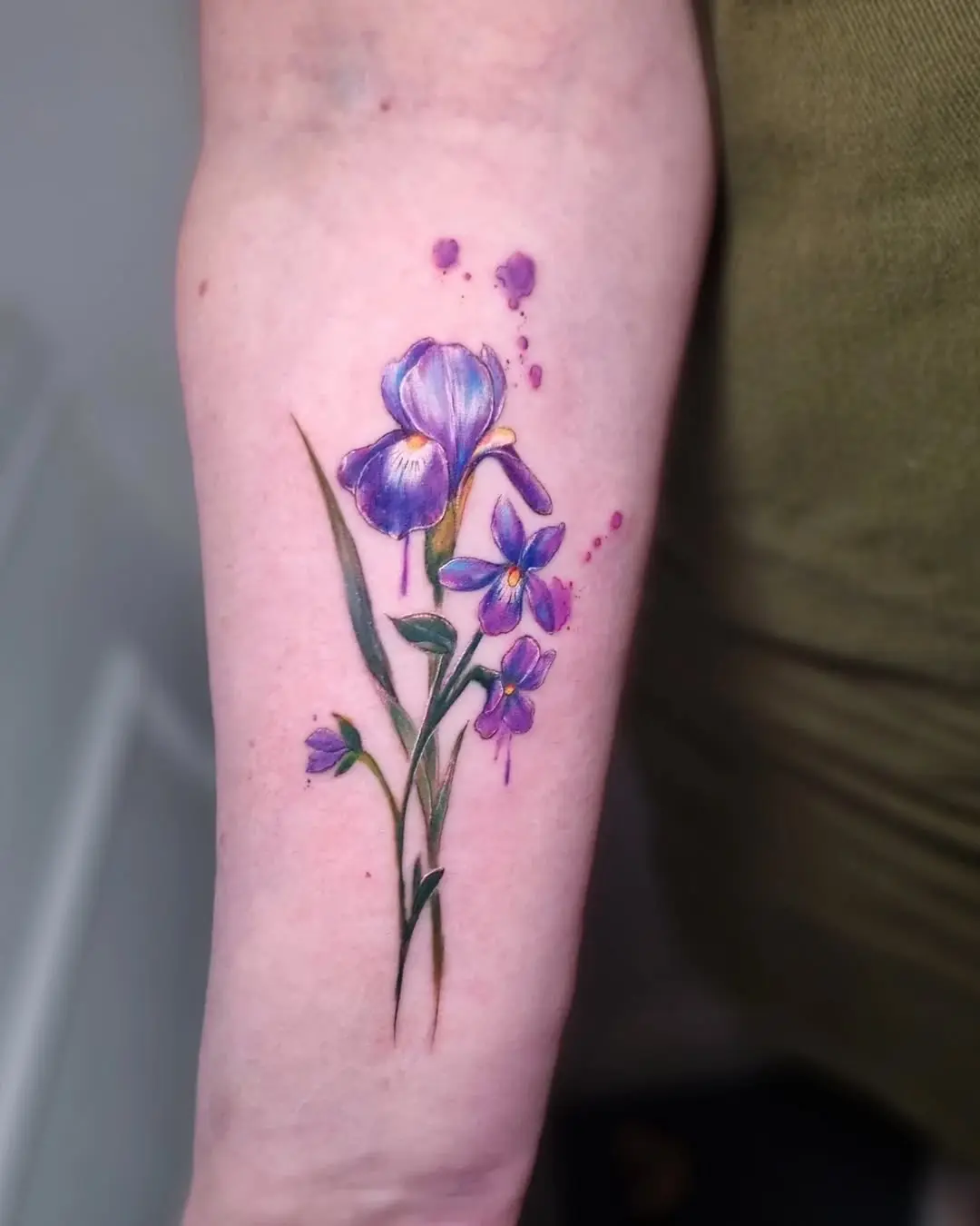 Elegant violet floral tattoo on arm