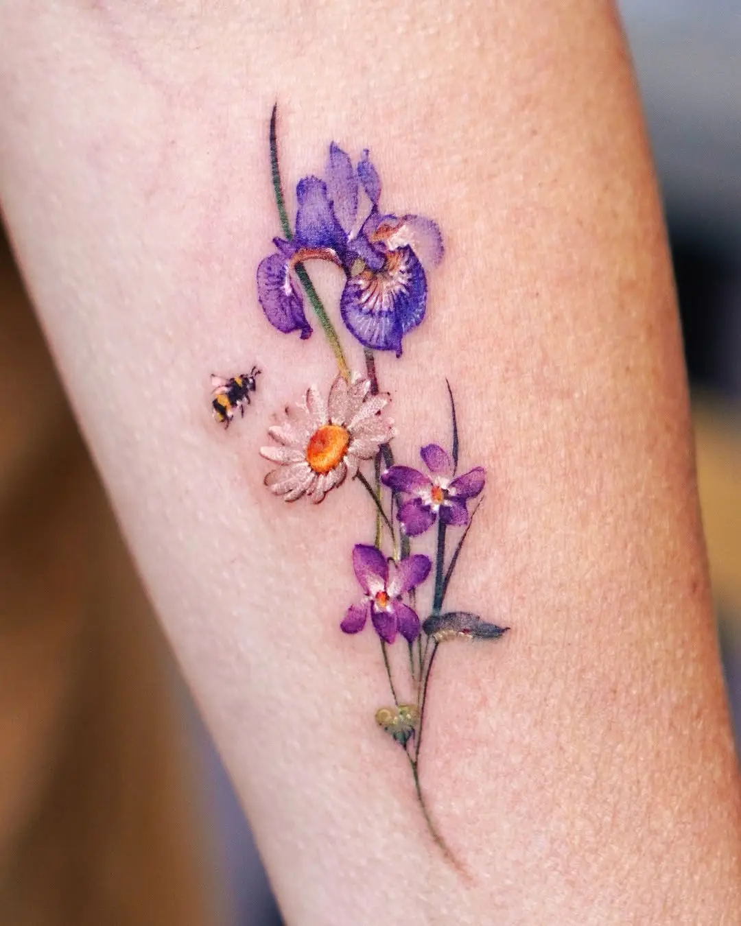 Vibrant violet floral tattoo with bee