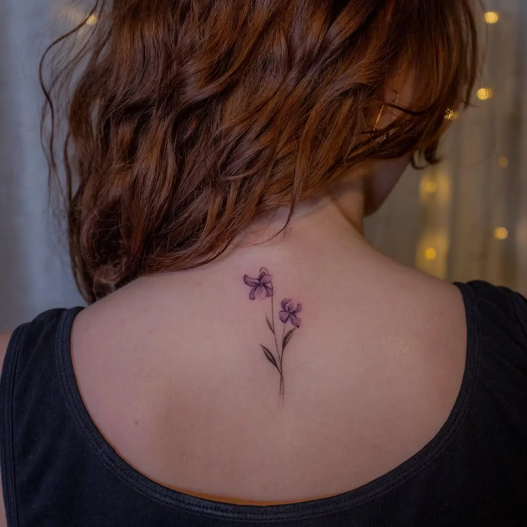 Delicate violet flowers inked on the back