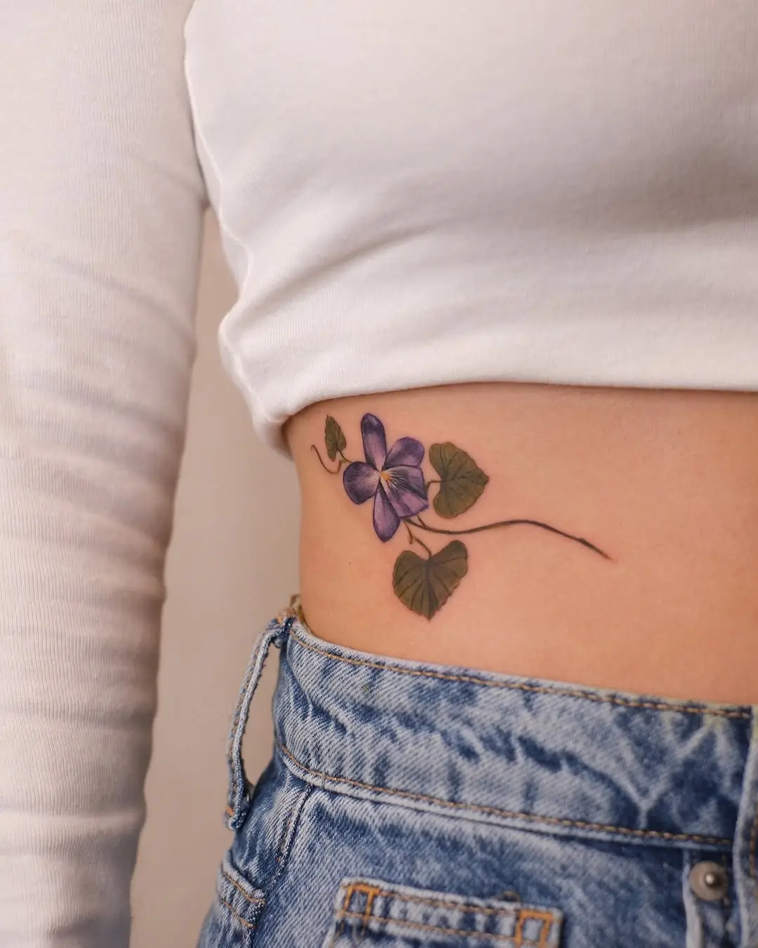 Elegant violet tattoo on the side of the body