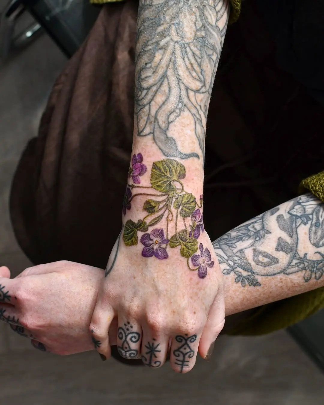Beautiful violet tattoo details on hand and arm