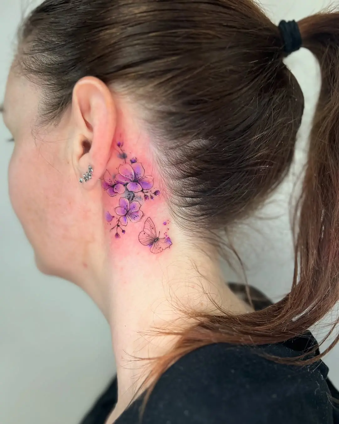 Beautiful violet floral tattoo with butterfly details