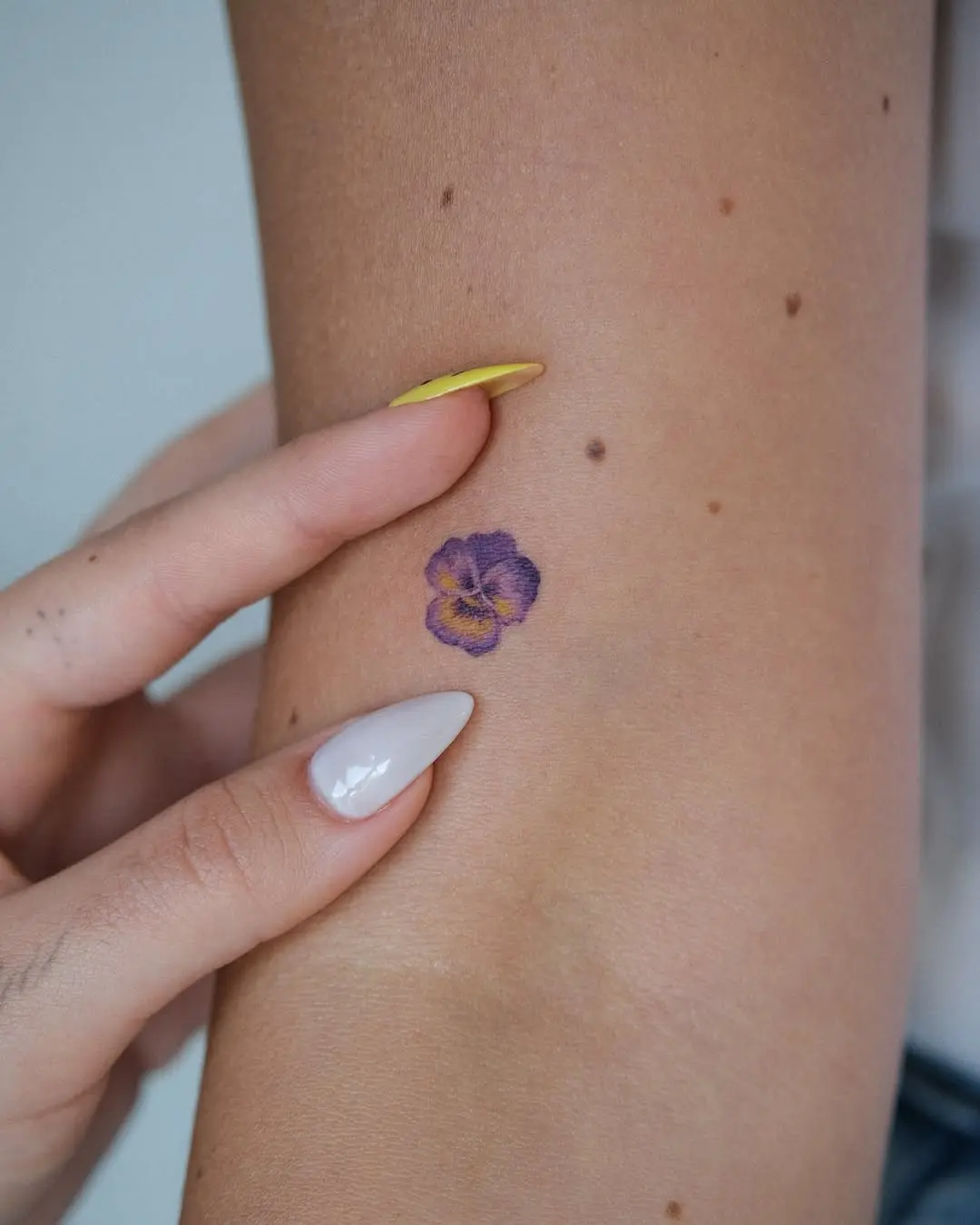 Elegant violet pansy tattoo on arm
