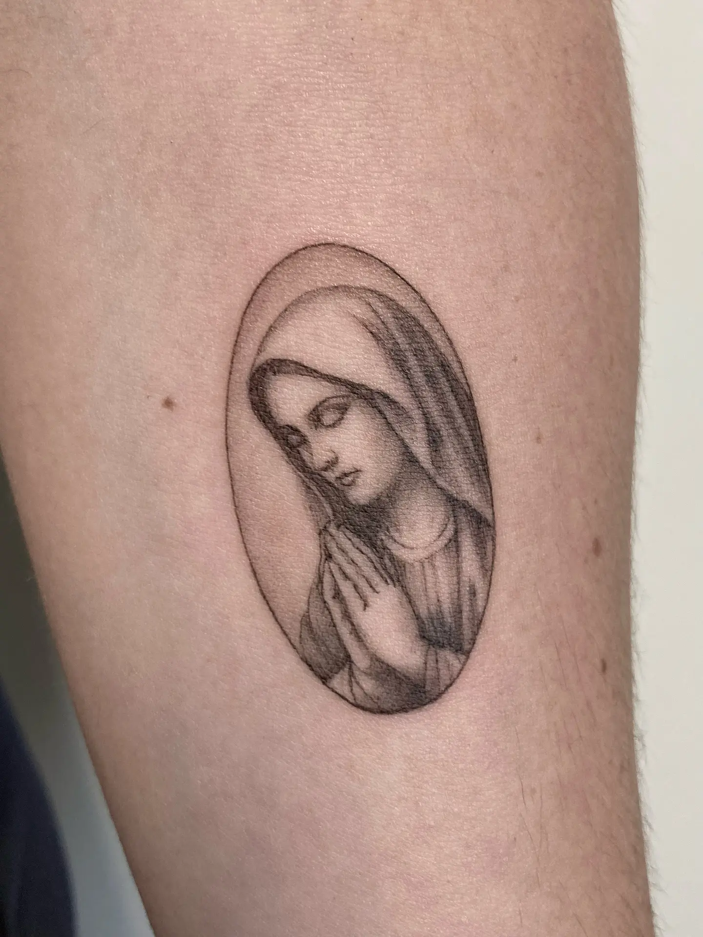Elegant Virgin Mary tattoo in prayer pose