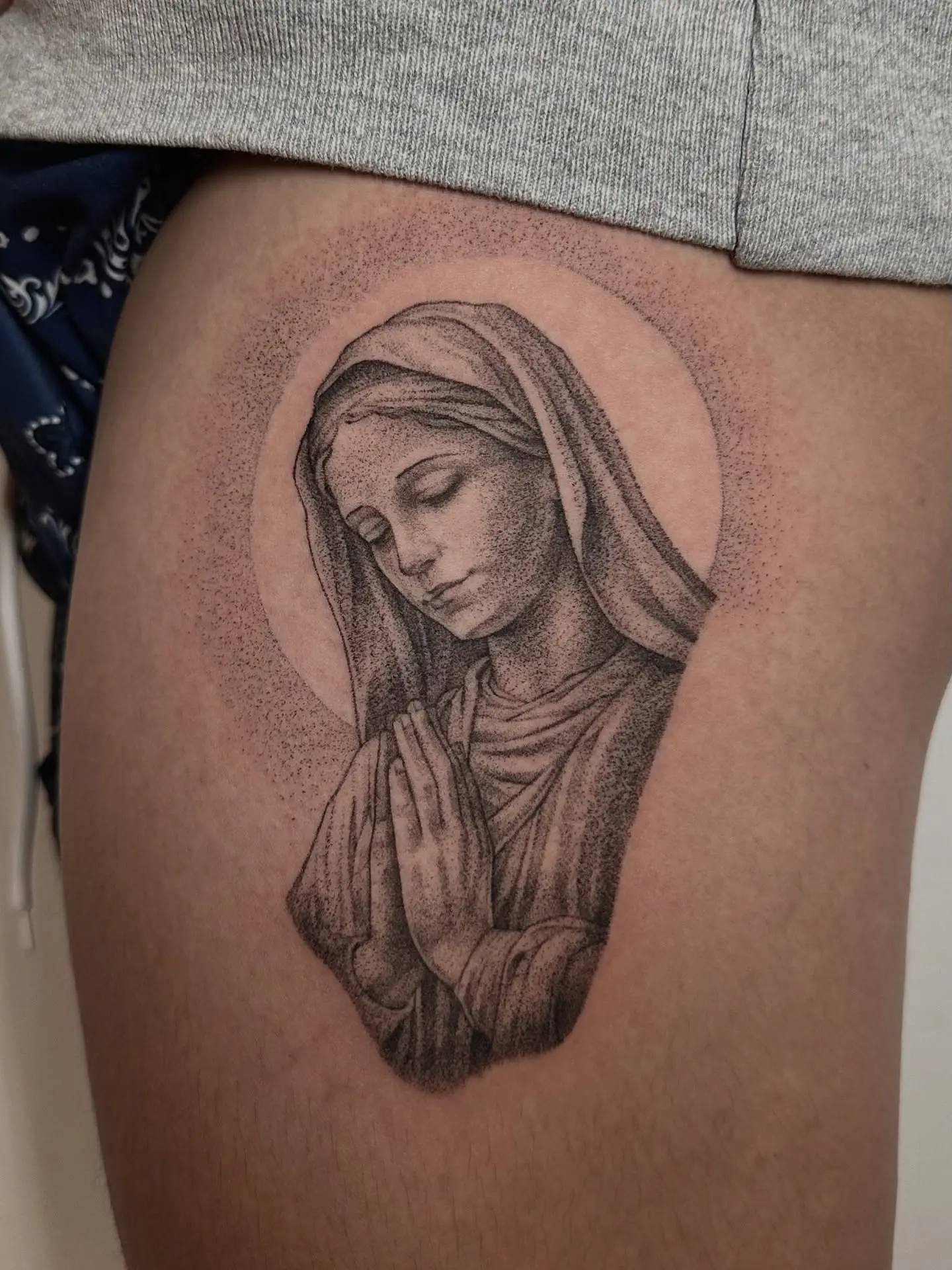 Intricate Virgin Mary tattoo in a praying pose