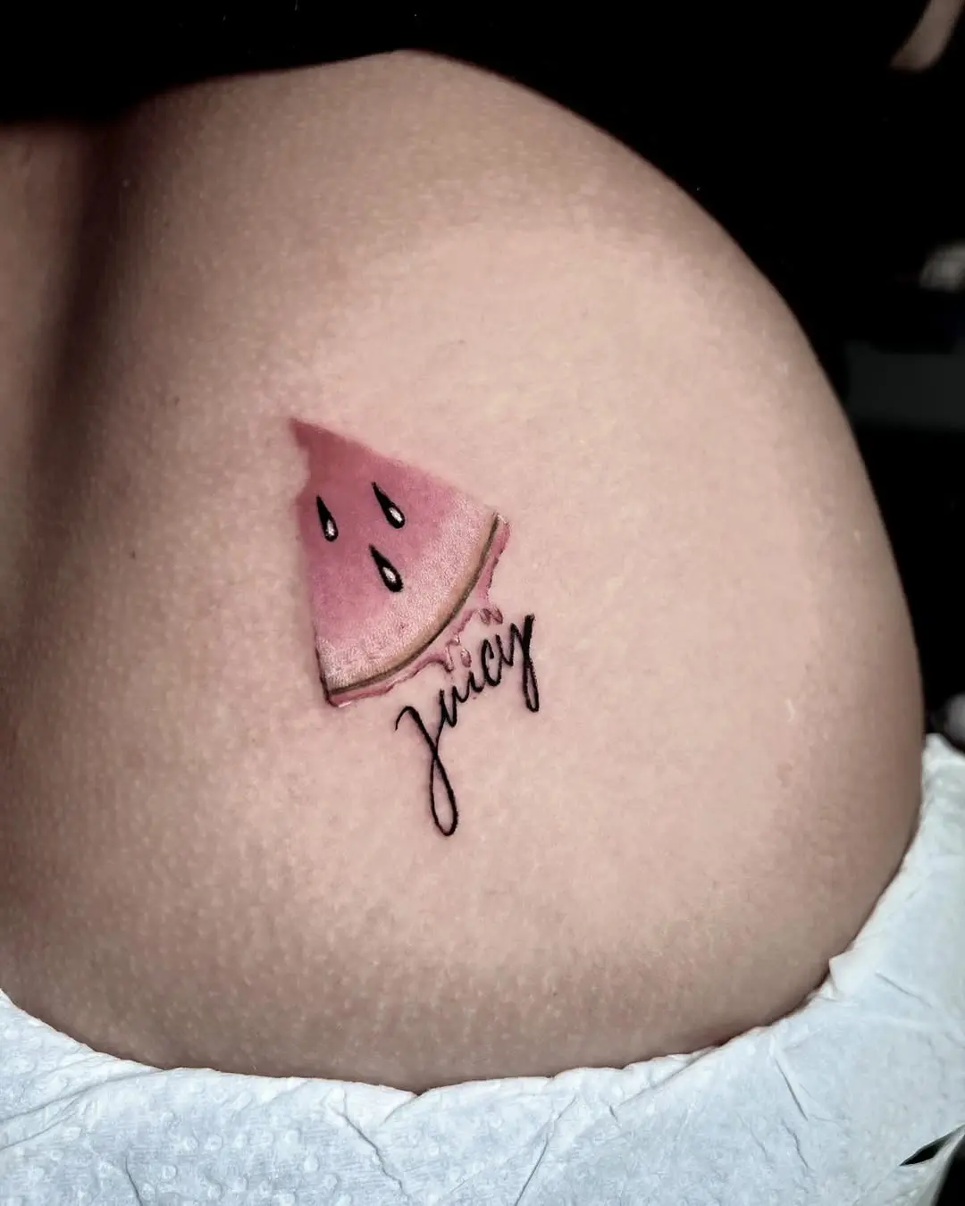 Vibrant watermelon slice tattoo with playful script