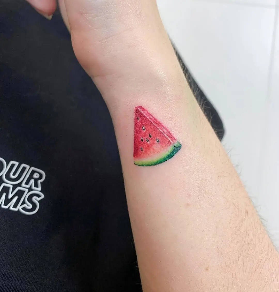 Colorful watermelon slice tattoo on the arm