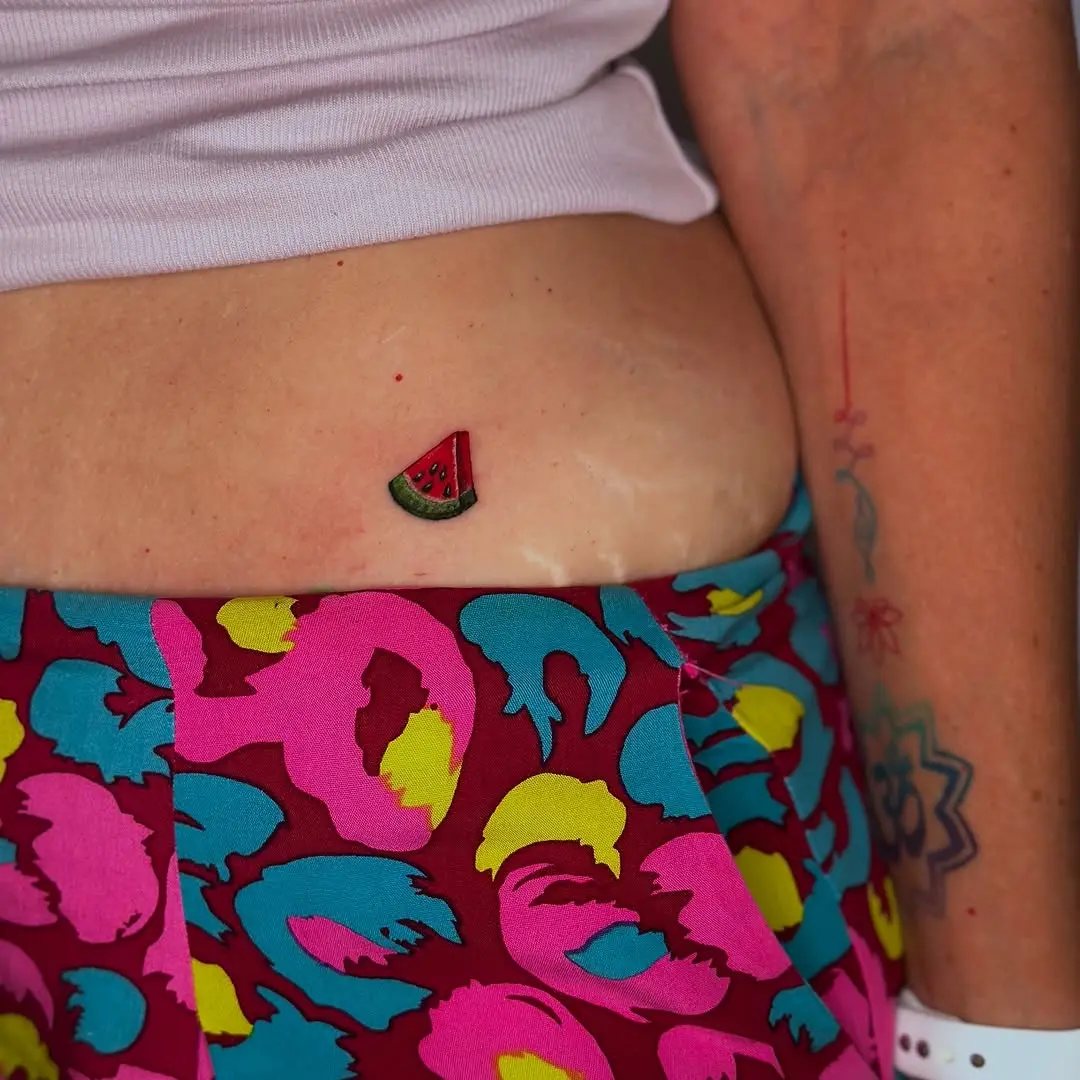 Brightly colored watermelon tattoo on the belly