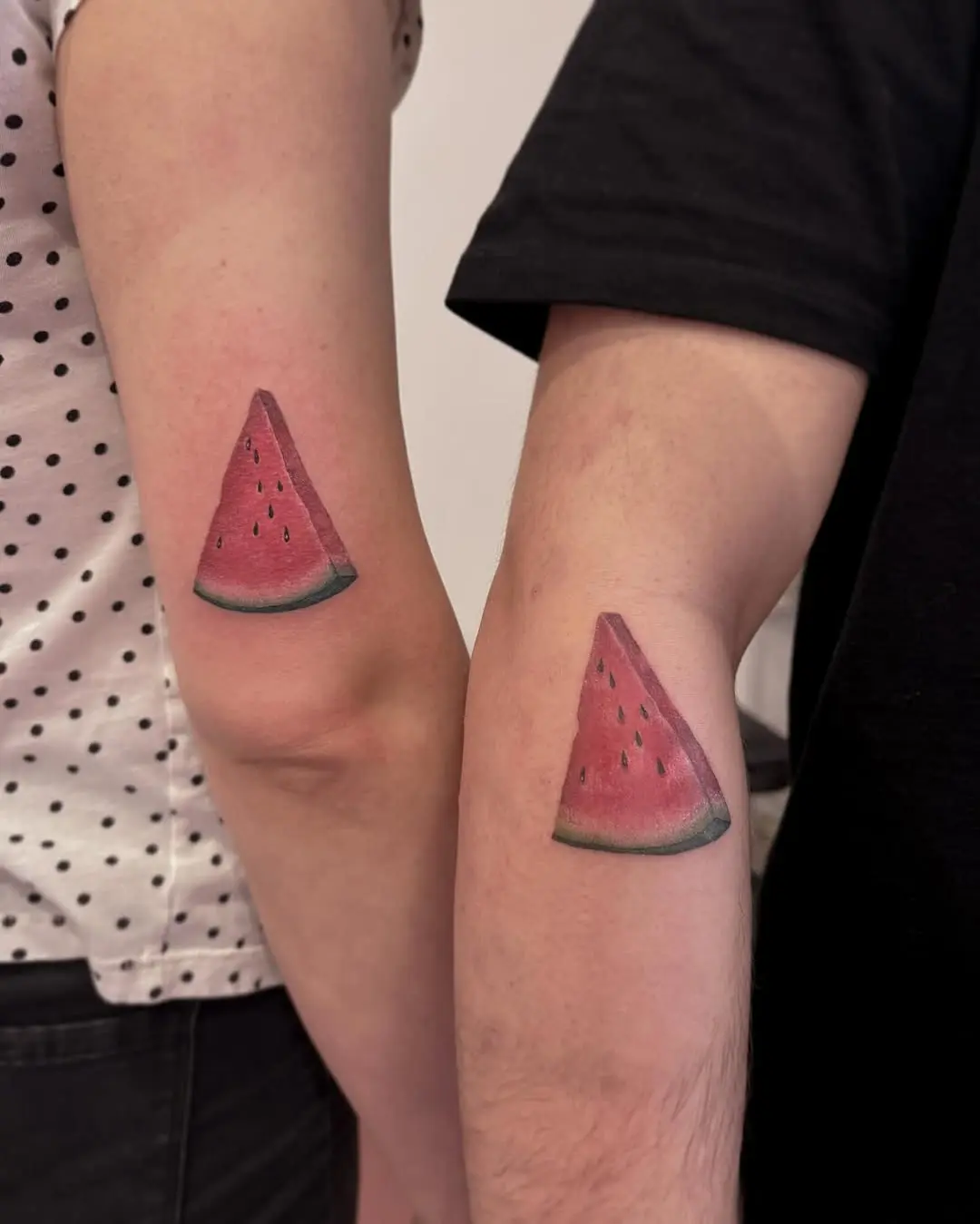 Colorful watermelon tattoos on forearms