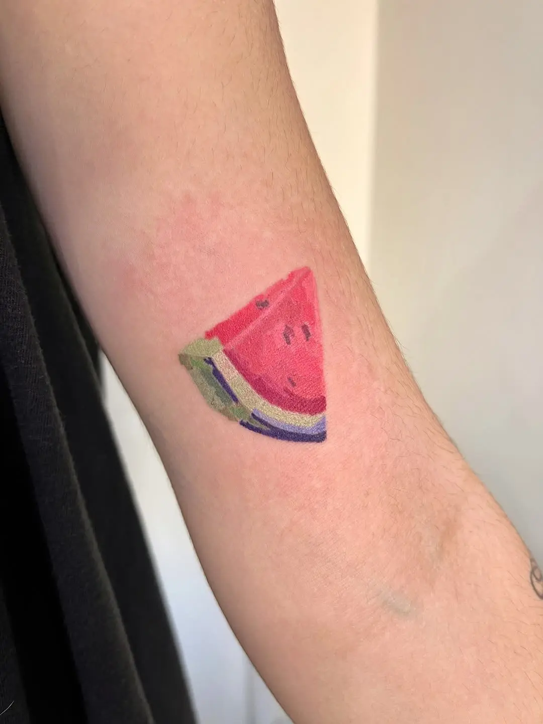 Colorful watermelon tattoo on the arm