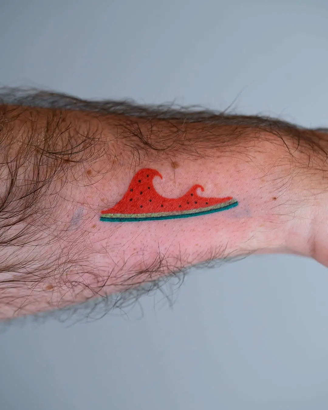 Unique wave-shaped watermelon tattoo design