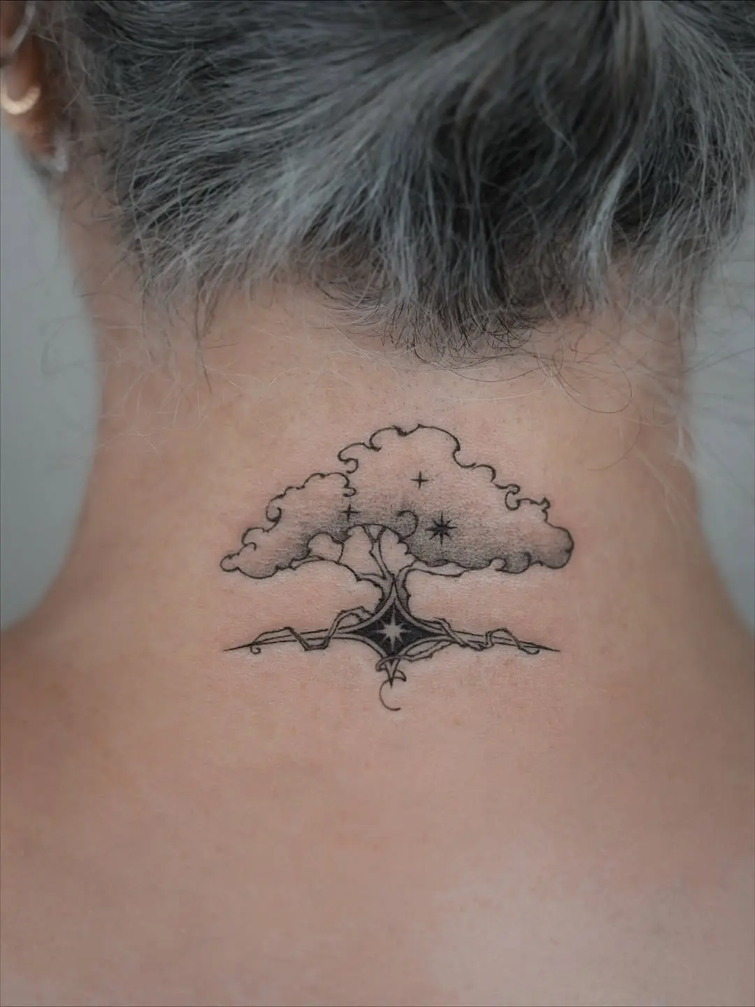 Stylish neck tattoo featuring leafy birch tree