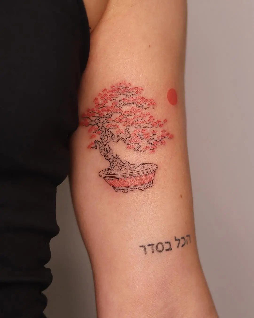 Elegant bonsai tattoo adorned with red hues