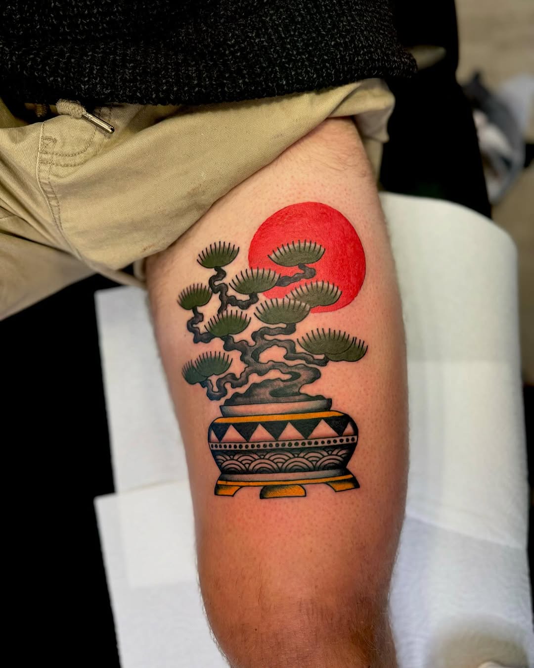 Vibrant bonsai tattoo with red sun detail
