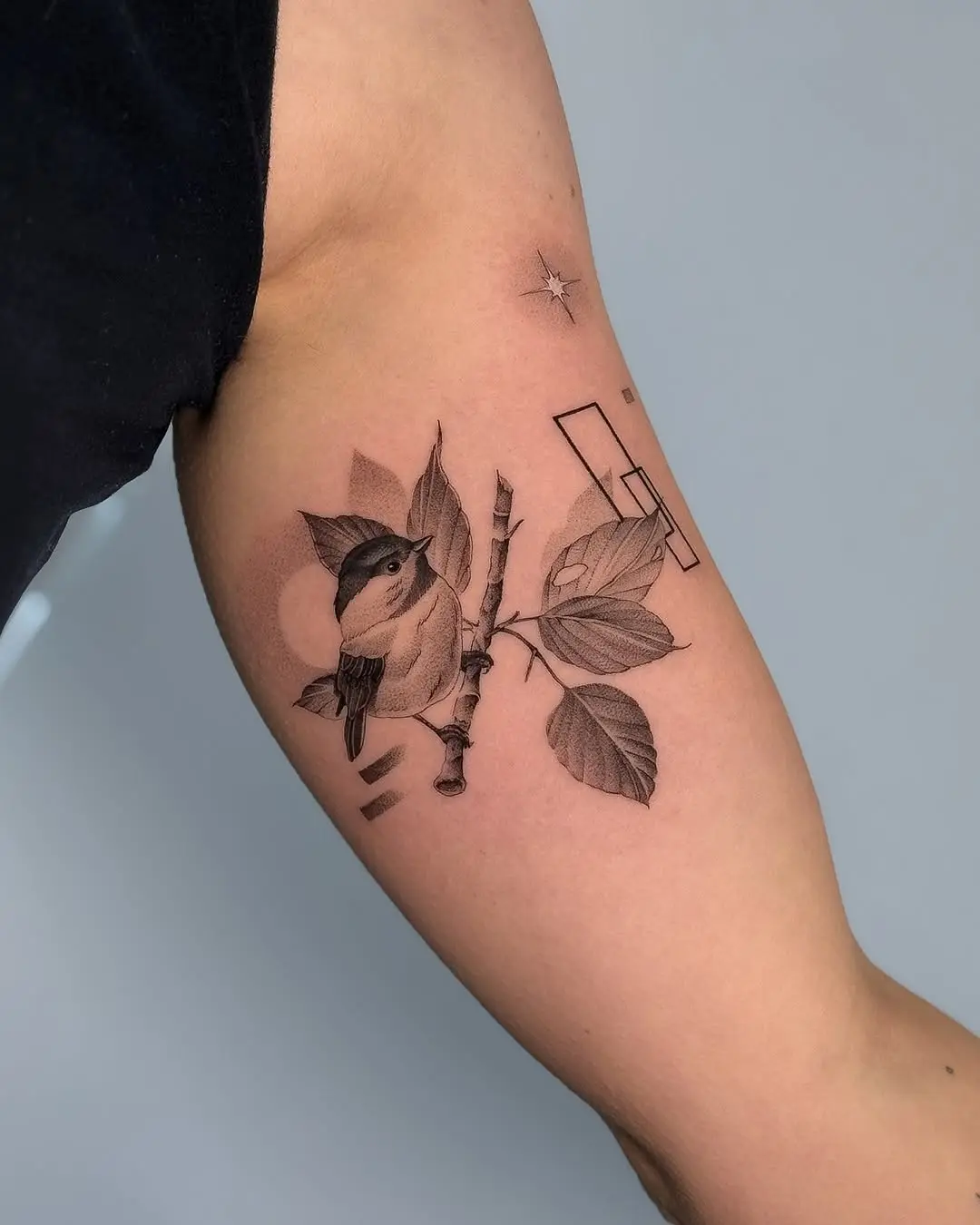 Elegant bird perched on leafy branch tattoo