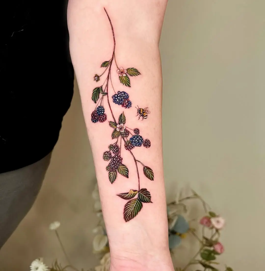 Elegant blackberry branch tattoo on forearm