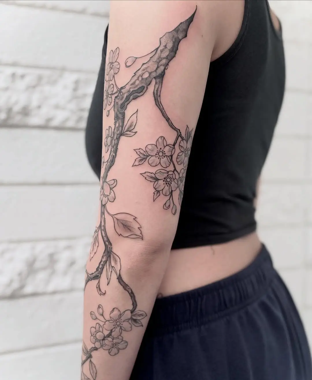 Elegant floral branch tattoo design on arm