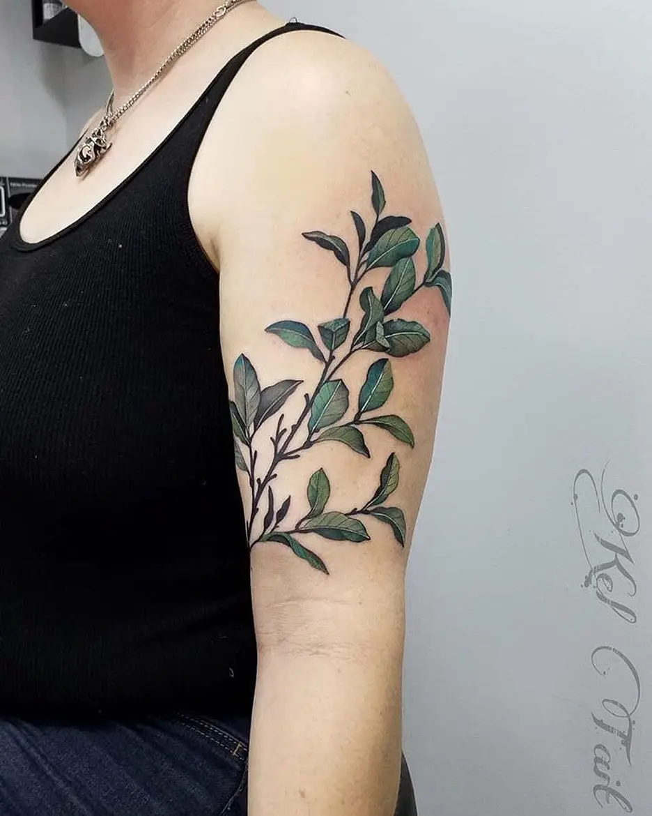 Elegant branch tattoo showcasing vibrant green leaves