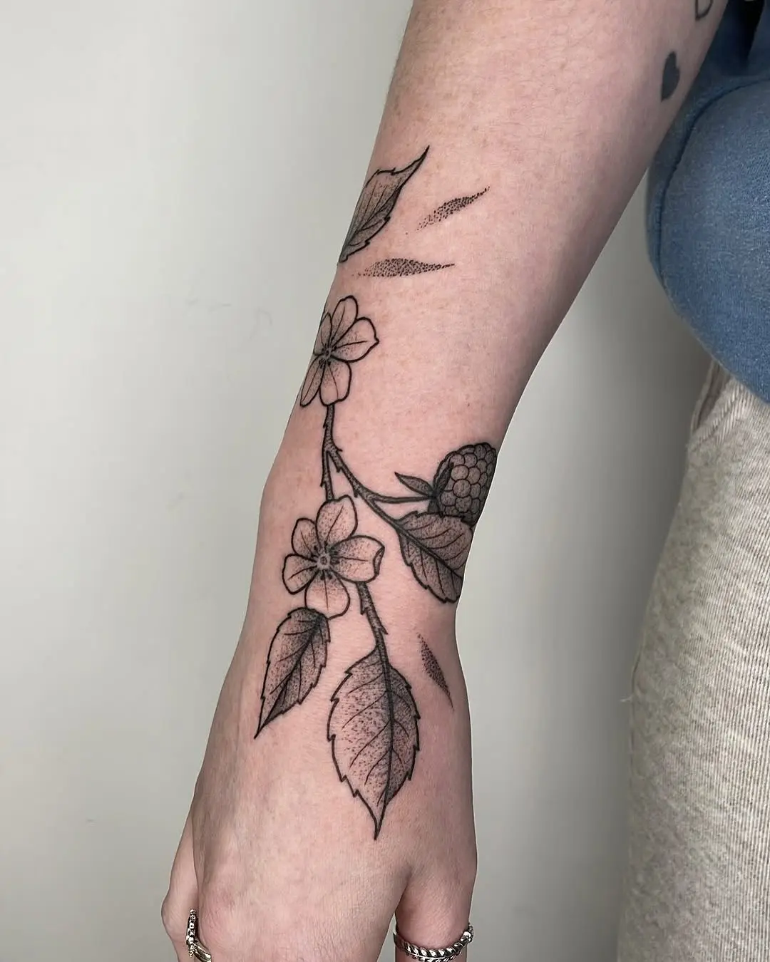Elegant floral branch tattoo on the forearm