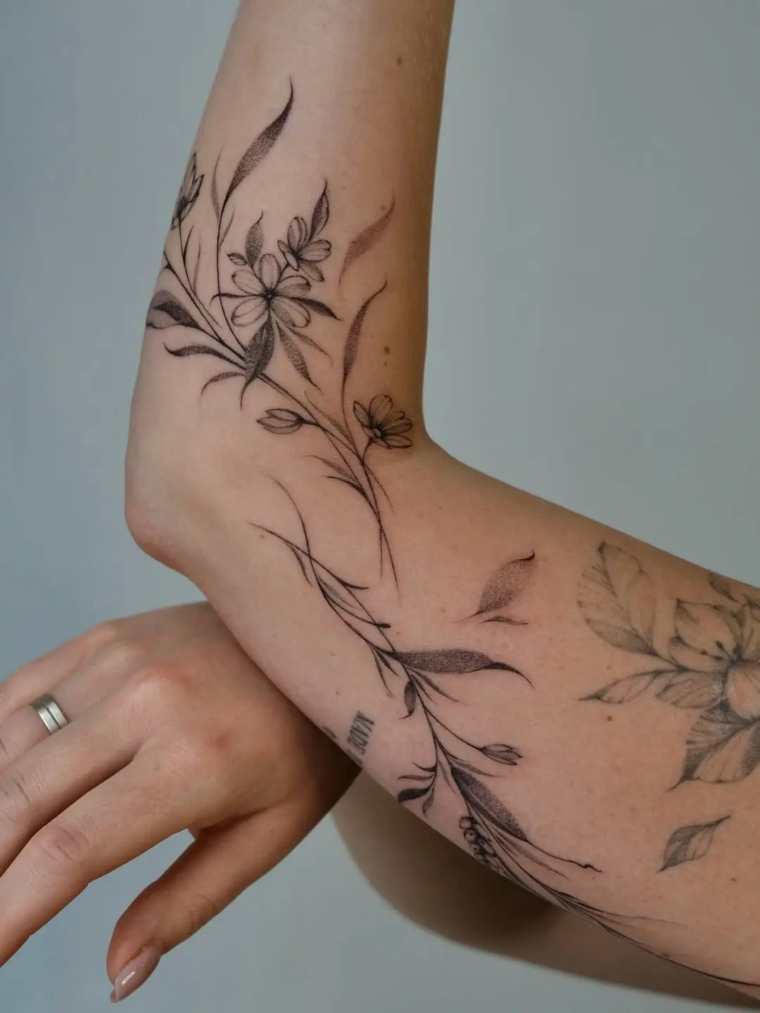 Elegant floral branch tattoo on the forearm