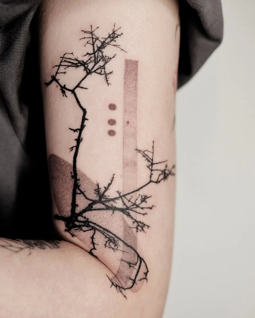 Elegant branch tattoo with minimalist design elements